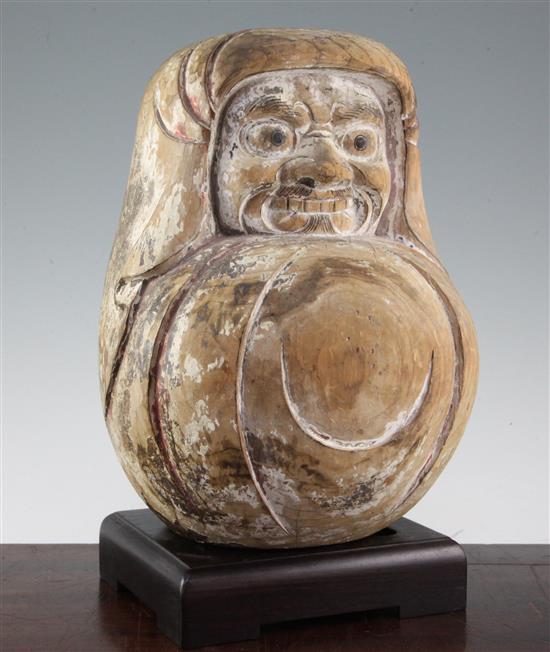 A Japanese carved and painted pine Daruma doll, 19th century, 32cm, associated wood stand